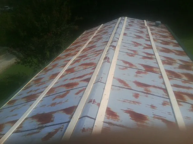 Rusted metal roof panels with new wood purlins before replacement — Storm Damage Roof Repair in Cataula by Roofing Brothers